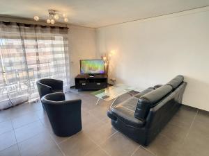 カンヌにある3 Bedrooms, 3 bathrooms central Cannes Lecerf 411のリビングルーム(ソファ、椅子2脚、テレビ付)