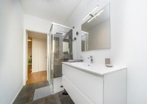 a white bathroom with a sink and a mirror at Cozy & Bright Apartment - w/ Balcony in Udine +15 photos