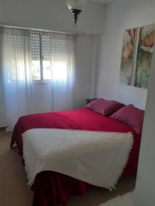 a red and white bed in a white bedroom at Apartamento El Cerrito in Tandil +15 photos