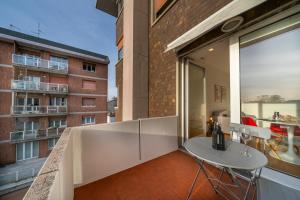 a balcony with a white table and a building at Cozy & Bright Apartment - w/ Balcony in Udine