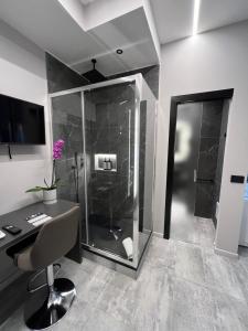 baño con ducha, escritorio y ordenador en Hey Suite Luxury GuestHouse Roma-Trastevere, en Roma