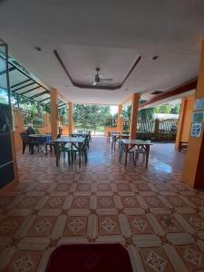 a room with tables and chairs on a tiled floor at Jessa's 5 Guests house in Moalboal