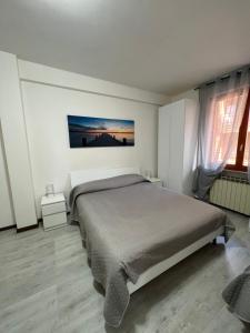 a bedroom with a bed in a white room at Your home outlet 4 in Serravalle Scrivia