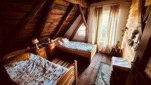 een zolderkamer met 2 bedden en een raam bij Dom z Charyzmą na Mazurach in Miłki