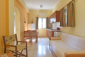 een woonkamer met een bank en een keuken bij Butterfly Barbati apartments in Barbati