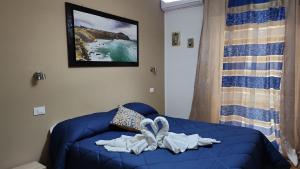 - un lit bleu avec une serviette dans l'établissement Milazzo La Porta Delle Eolie 2.0, à Milazzo