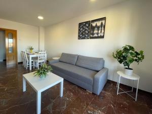 a living room with a couch and a table at Apartamentos El Pilar Suites 3000 in Zaragoza