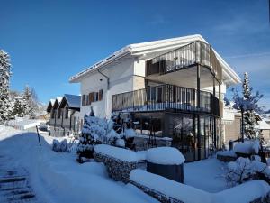 una casa blanca con nieve en el suelo en Klein aber fein, en Escholzmatt