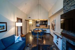 un soggiorno con divano blu e tavolo di The Eagle Suite at Stoneridge Mountain Resort a Canmore