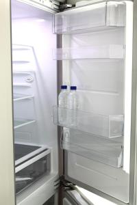 an open refrigerator with bottles of water in it at Elliy's Room in Busan