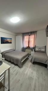 a bedroom with two beds and a table at Your home outlet 4 in Serravalle Scrivia