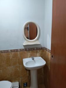ein Bad mit einem Waschbecken und einem Spiegel in der Unterkunft Dulces Sueños in Huancayo