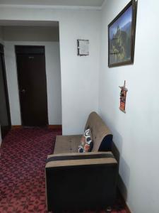 ein Zimmer mit einem Sofa in der Ecke eines Zimmers in der Unterkunft Dulces Sueños in Huancayo