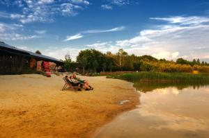 two people sitting in a chair on the beach at Ferienhaus 4 Personen FH6 