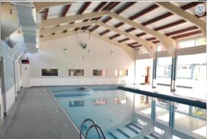 a swimming pool in a building with a ceiling at 73 Palm Lodge in Kingsdown