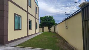 un vicolo tra due edifici con un albero al centro di Pousada Pé na Areia a Rio das Ostras
