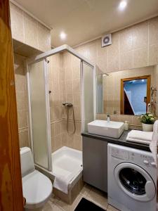 a bathroom with a toilet a sink and a washing machine at Apartments Superdom in Dnipro