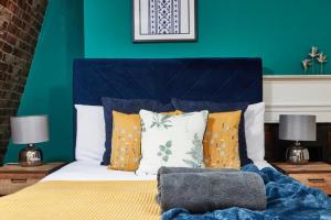 1 dormitorio con 1 cama con pared azul en The Beautiful Central Gem Of Bath - Sleeps 24!, en Bath