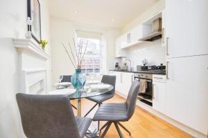 a dining room with a table and chairs in a kitchen at The Beautiful Central Gem Of Bath - Sleeps 24! in Bath