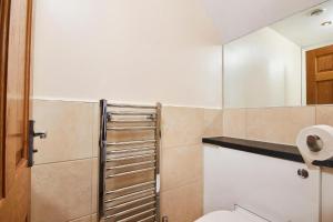 a bathroom with a toilet and a mirror at The Beautiful Central Gem Of Bath - Sleeps 24! in Bath