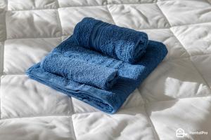 uma toalha azul sentada em cima de uma cama em Stay House MXP Airport em Gallarate