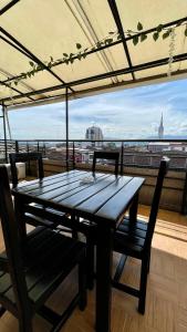 un tavolo in legno con sedie e un balcone con vista. di Hotel Sangil Tuluá a Tuluá