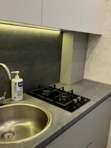 a kitchen counter with a sink and a stove at Apartments Superdom in Dnipro