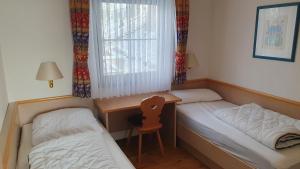 - une chambre avec deux lits, un bureau et une chaise dans l'établissement Lechbruck am See Feriendorf Hochbergle Haus 7, à Lechbruck am See