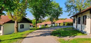 eine Straße, die zu einer Reihe von Häusern führt in der Unterkunft Lechbruck am See Feriendorf Hochbergle Haus 7 in Lechbruck