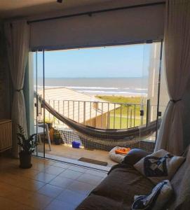 een woonkamer met uitzicht op het strand bij Lindo Apto com vista para o Mar! in Pontal do Paraná