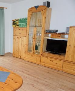 un armario de madera con TV en una habitación en Lechbruck am See Feriendorf Hochbergle Haus 1 en Lechbruck