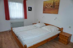 Una cama con sábanas blancas y almohadas en un dormitorio en Lechbruck am See Feriendorf Hochbergle Haus 1 en Lechbruck