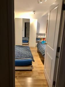 倫敦的住宿－Room 1 or 2 ppl near EXCEL, O2, Canary Wharf - London，一间设有两张床的房间和一扇通往卧室的门