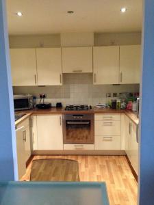 Una cocina con gabinetes blancos y un horno de estufa. en Room 1 or 2 ppl near EXCEL, O2, Canary Wharf - London, en Londres