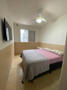 1 dormitorio con 1 cama con manta rosa en Lindo Apto com vista para o Mar!, en Pontal do Paraná