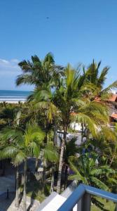 een balkon met uitzicht op de palmbomen en de oceaan bij Lindo Apto com vista para o Mar! in Pontal do Paraná