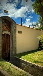 a building with a wooden door on the side of it at Casa Colonial com lareira in São Lourenço