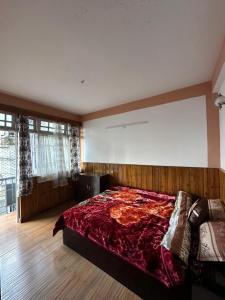 - une chambre avec un grand lit et une couverture rouge dans l'établissement Cloudy hills, à Darjeeling
