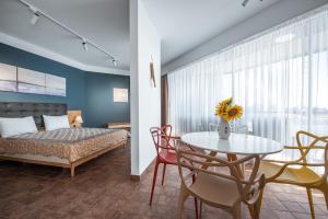 Apart-Hotel Safir في فينوس: غرفة نوم بسرير وطاولة وكراسي