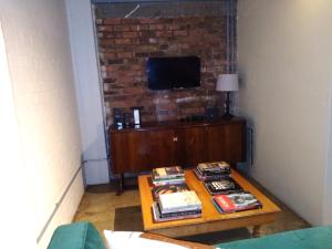a living room with a table with a tv on a brick wall at House of Cairo - Johannesburg in Johannesburg