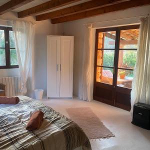 a bedroom with a bed and a large window at Studio Doppelzimmer 2 Pers mit Terrasse und Pool auf Finca Mallorca in Santanyi