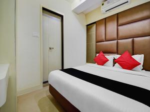 a bedroom with a large bed with red pillows at Hotel Snowfox in Madhyamgram