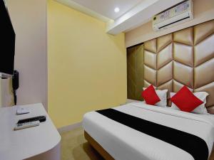 a bedroom with a large bed with red pillows at Hotel Snowfox in Madhyamgram