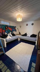 a room with two beds and a rug at Mar & Ilha - Guest House - Praia de Maresias in São Sebastião