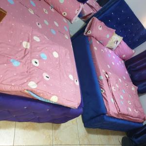 a couple of pink beds with pillows on them at Vee female hostel in Wupa