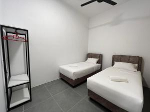 Cette chambre comprend 2 lits et un miroir. dans l'établissement Langkawi - Simfoni Beliza Homestay, à Kuah