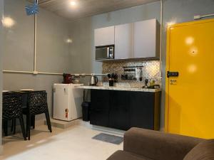 a kitchen with a counter and a yellow door at Brás, Feirinha da Madrugada, Expo Center Norte, Vaultier in Sao Paulo