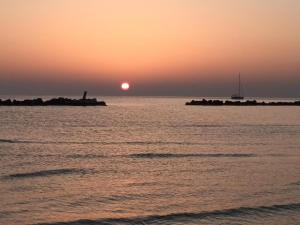einen Sonnenuntergang über einem Wasserkörper mit einem Segelboot in der Unterkunft B&B Stella dell'Adriatico in Ortona