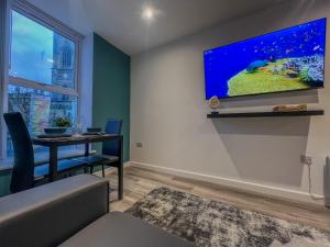 a dining room with a table and a tv on the wall at Orange Rentals-City Centre - High Spec - The Aqua Suite, Sleeps 4 in Liverpool