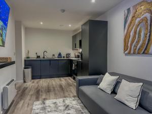 a living room with a couch and a kitchen at Orange Rentals-City Centre - High Spec - The Aqua Suite, Sleeps 4 in Liverpool
